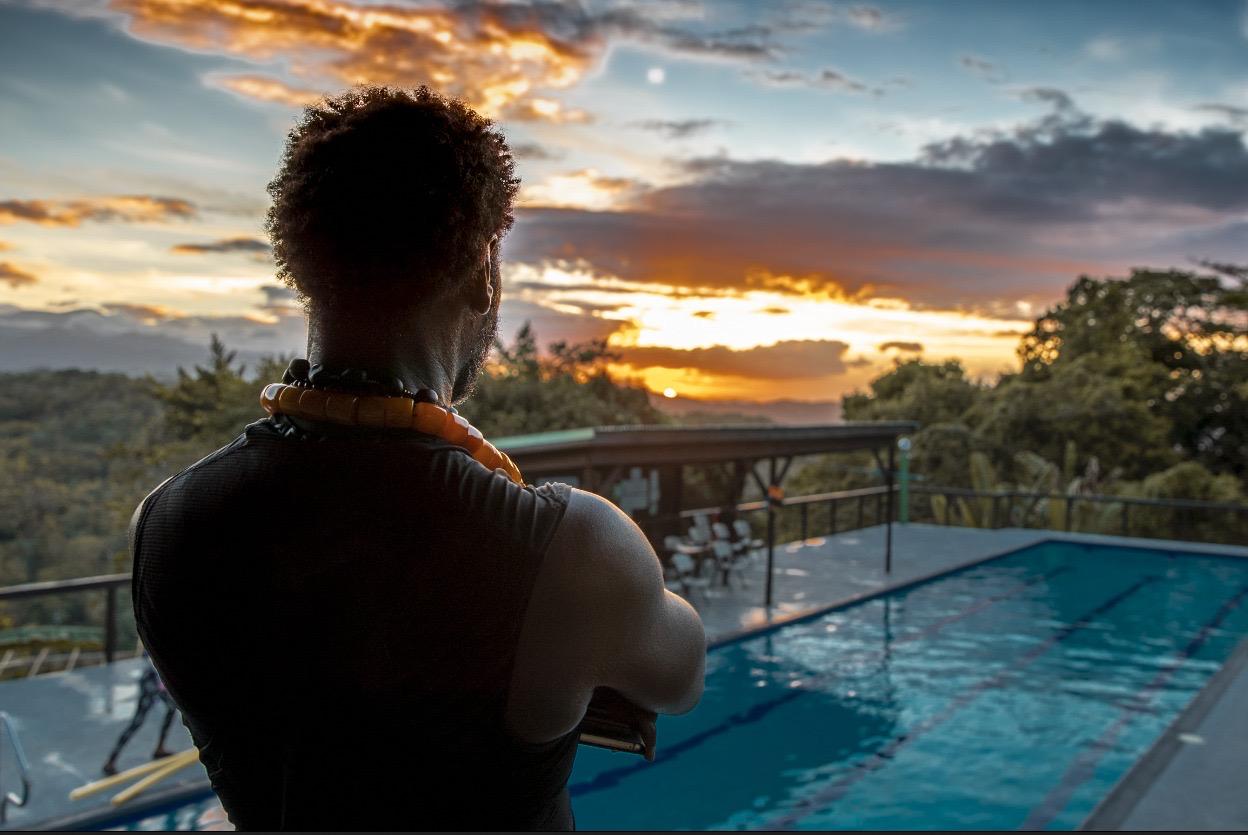 Eugene looking out at sunset over the mountains of Jamaica