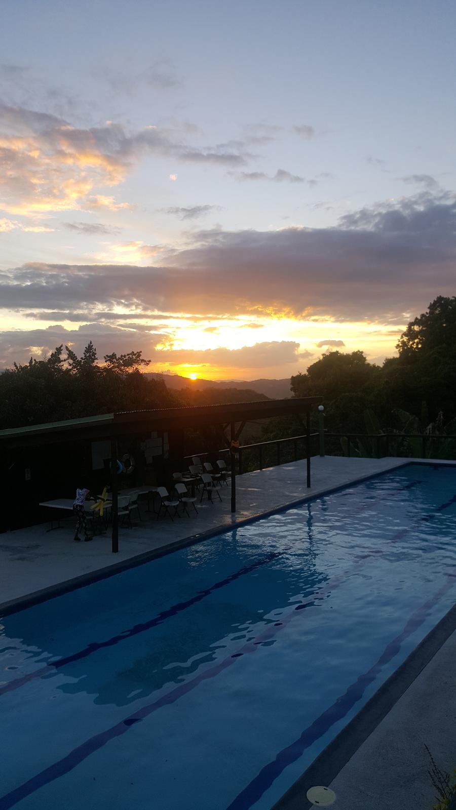 Wide sunset over the pool and mountain landscape